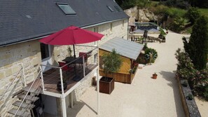 Un bâtiment en pierre doté d’un patio, d’un espace extérieur aménagé pour s’asseoir et d’un petit jardin.