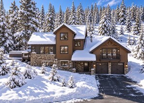 A two-story lodge with a stone foundation, wooden siding, and a snow-covered roof. - Serene home on 2 Acres, Minutes to Slopes, Private Hot Tub (Breckenridge)