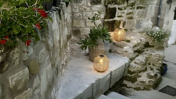 Eine Steintreppe mit Stufen, die zu einer mit Pflanzen und Blumen bewehrten Mauer hinaufführen.