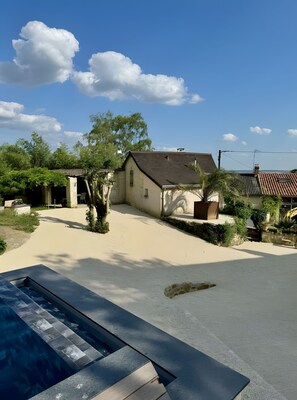 Een woonwijk met een zwembad, een huis met een pannendak en een heldere lucht.