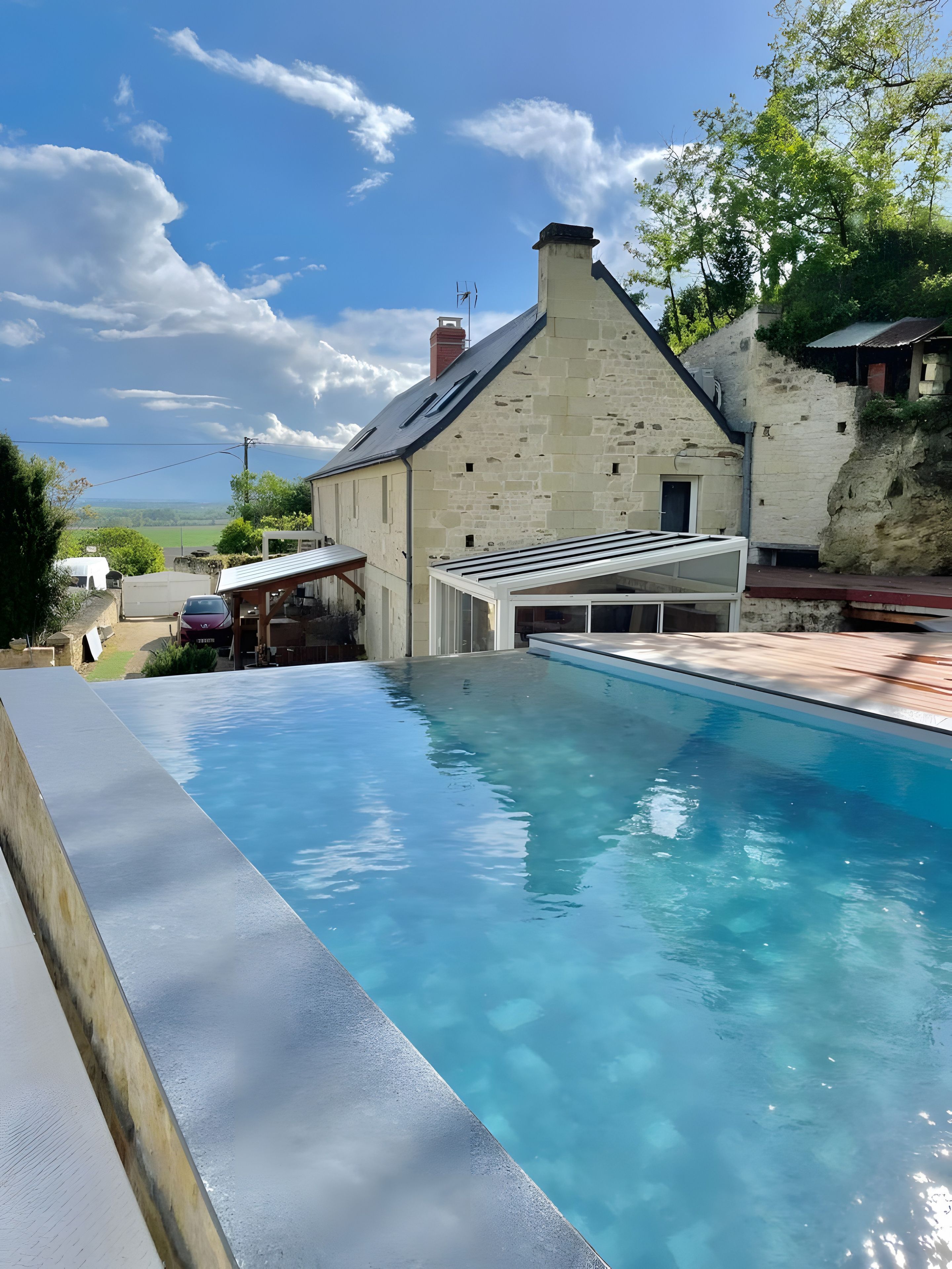 Une piscine avec un bâtiment en pierre en arrière-plan.