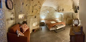 Une pièce rustique comprenant un lit, un canapé et une horloge murale.