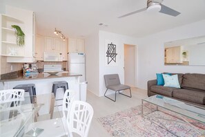 A modern living space with a kitchen, dining area, and seating area. - ☀️Summer Breeze 302 | Gulf Views~Pool+Hot Tub~Balcony~Walk to Beach⛱️ (Miramar Beach)