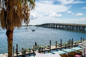 Blick auf das Wasser mit einer langen Pier, Booten und einem Yachthafen mit Reihen von Kanus und einem Schild mit der Aufschrift 'Harborwalk Marina'.