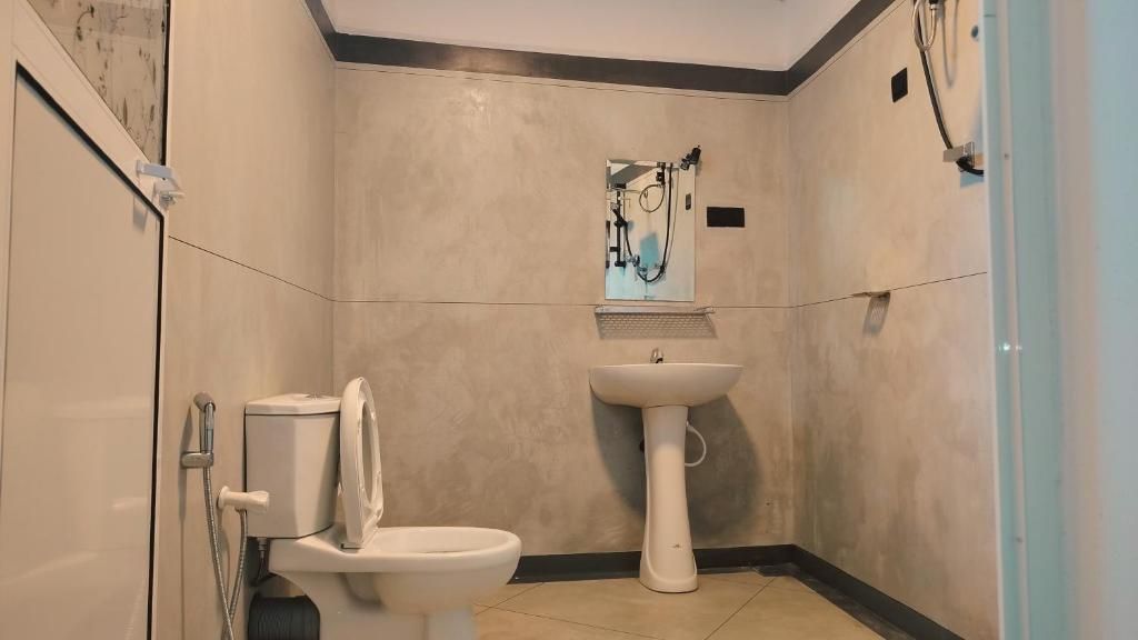 A bathroom with a toilet, sink, and shower.