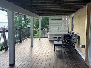 Eine Holzterrasse mit eingebautem Whirlpool und Sitzgelegenheiten im Freien.