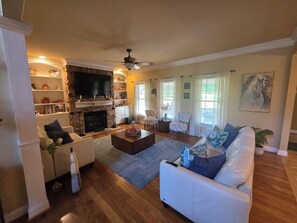 A living room with a fireplace, white sofas, a coffee table, and a television. - 10 Minute drive from Keeneland - Spacious 5-bedroom house in Nicholasville (Nicholasville)