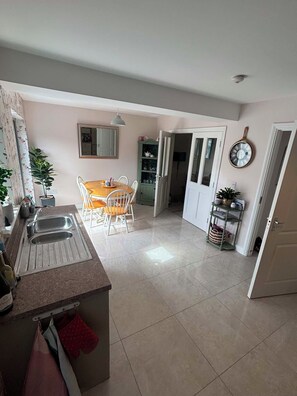 A kitchen with a dining area, a sink, and a cabinet.