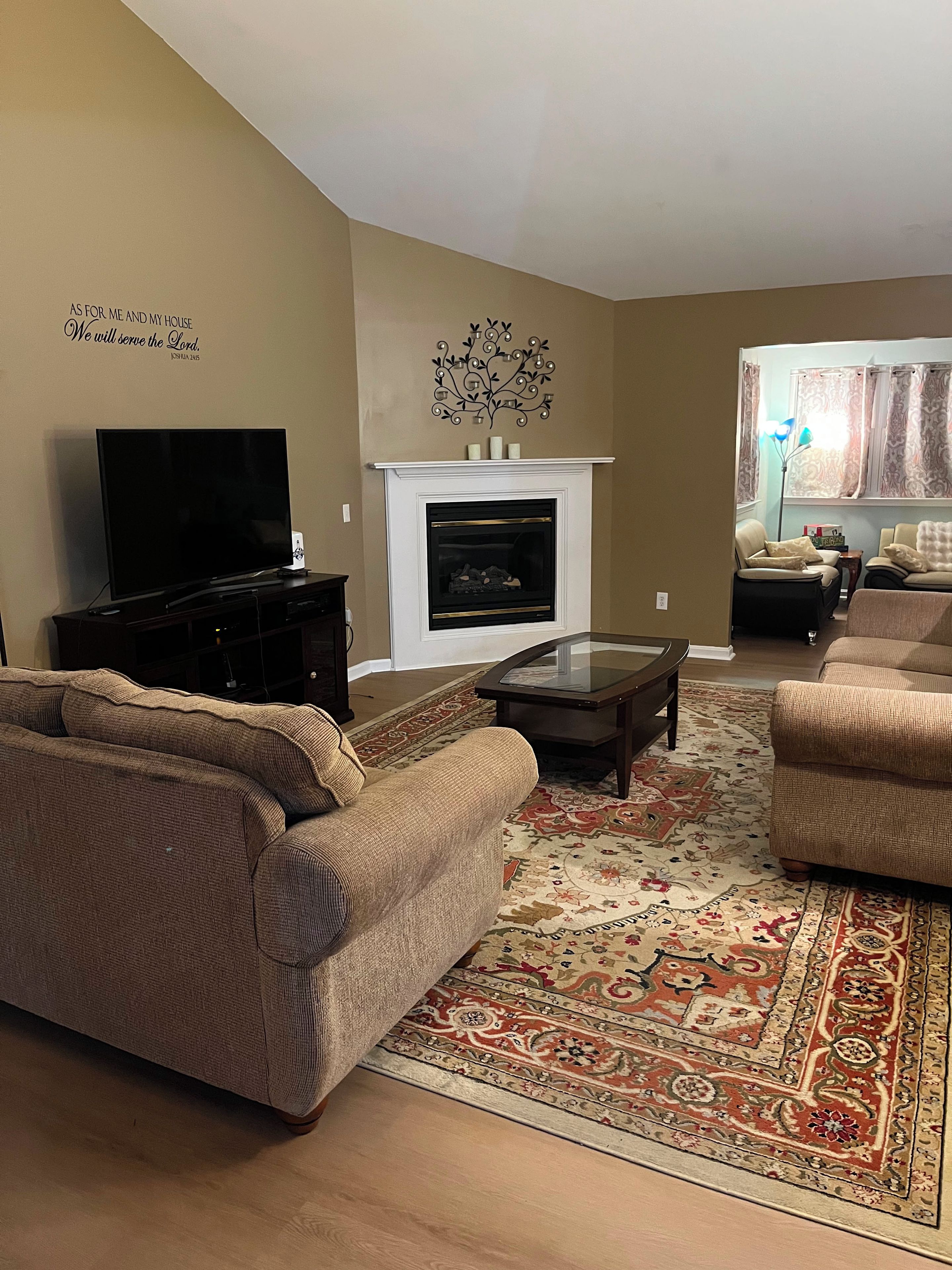 A living room with a fireplace, a television, and a sofa.