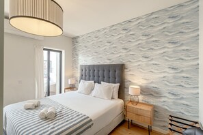 Une chambre d’hôtel avec un lit, une table de chevet, une lampe et une vue sur l’extérieur grâce à une porte coulissante.