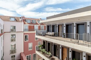 Un immeuble résidentiel à plusieurs étages, doté de balcons, d’une terrasse et d’un style architectural moderne.