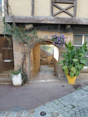 A narrow alleyway leading to a stone building with a wooden door and a number sign. - Guesthouse 'Le 101' with private garden (Villedieu-les-Poêles-Rouffigny)