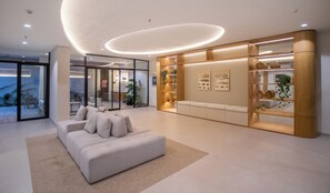 A modern interior with a sofa, a wooden display unit, and a glass partition. - Corporate Stays Habitalis Mburucuya- 15E (Asunción)