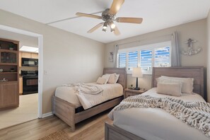 A bedroom with two beds, a ceiling fan, a window with blinds, and a view of the sky. - Carlos Pointe #224 | Beautiful Beachfront Condo, Gulf Views + Pool 🌊 (Fort Myers Beach)