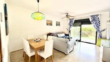 Un espacio habitable moderno con comedor, sofá y ventilador de techo.