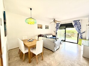 Un espacio habitable moderno con comedor, sofá y ventilador de techo.