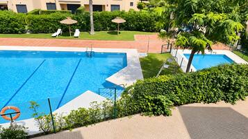 Piscina con una silla de salvavidas y una palmera.
