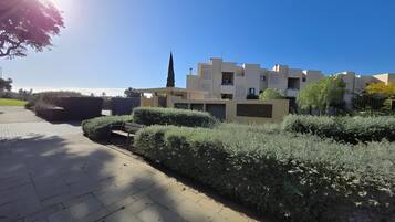 Zona residencial con edificios modernos, un sendero pavimentado y setos bien cuidados.