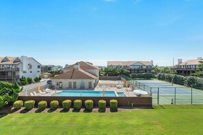 A residential area with a swimming pool, tennis court, and a small building with a sloped roof. - Sea Dunes D1: Coastal Retreat with Ocean Views (Kitty Hawk)