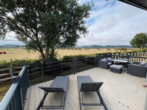 A deck with outdoor furniture overlooking a field and hills. - Ty Mawr Holiday Park Swift Toronto Lodge (Abergele)