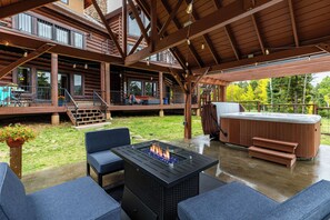 A covered outdoor area with a hot tub, seating, and a fire feature. - Sundance Lodge in Angel Fire (Angel Fire)