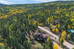 A cabin surrounded by dense forest with a clear sky. - Sundance Lodge in Angel Fire (Angel Fire)