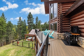 A wooden deck with outdoor seating and a barbecue grill. - Sundance Lodge in Angel Fire (Angel Fire)
