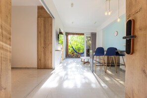 A modern interior with a dining area, a hammock, and a view of greenery. - Utopía 2.West-StylishApt•OpticalFiber•Self CheckIn (Medellín)