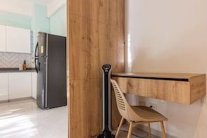 A modern kitchen with a built-in refrigerator, wooden paneling, and a chair. - Utopía 2.West-StylishApt•OpticalFiber•Self CheckIn (Medellín)