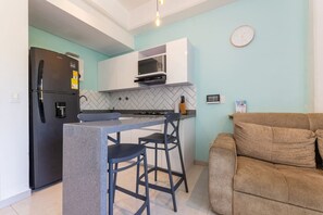 A compact kitchen with a refrigerator, microwave, and bar stools. - Utopia 2.East-Serene Loft•SelfCheckIn•OpticalFiber (Medellín)