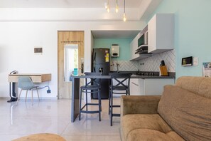 A modern kitchen with a central island, bar stools, a dining table, and a sofa in a living area. - Utopia 2.East-Serene Loft•SelfCheckIn•OpticalFiber (Medellín)