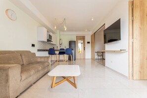 A modern living room with a sofa, a coffee table, and a TV. - Utopía 4.West - Shining 2BR•Wi-Fi•AC•Self Check-In (Medellín)