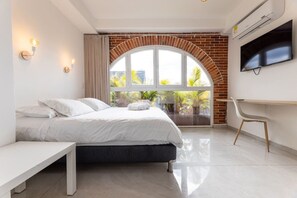 A modern bedroom with a bed, a desk, and a TV. - Utopia 5.West - Bright 2BR•AC•Self Check-In•Wi-Fi (Medellín)