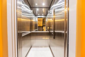 A modern elevator with metallic walls and a central control panel. - Utopía M.East-Peacefull Loft•Wi-Fi•Self Check-In (Medellín)