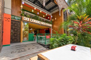 A restaurant with outdoor seating, a wooden facade, and decorative hanging lights. - Utopía M.East-Peacefull Loft•Wi-Fi•Self Check-In (Medellín)