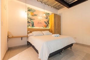 A bedroom with a bed, a wooden headboard, a wall mural, a bedside table, and a hanging light fixture. - Utopía M.East-Peacefull Loft•Wi-Fi•Self Check-In (Medellín)