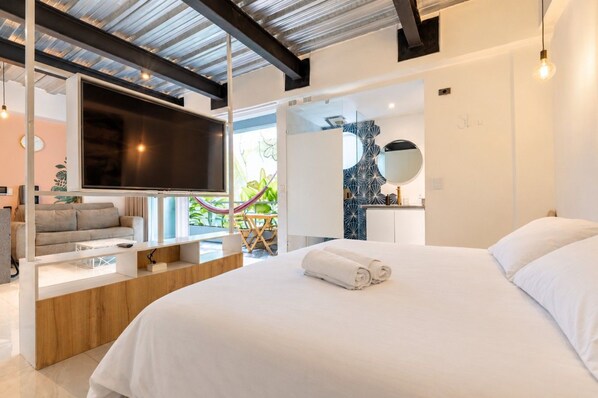 A modern hotel room with a large bed, a flat-screen TV, a sofa, and a dining area. - Utopía M.East-Peacefull Loft•Wi-Fi•Self Check-In (Medellín)