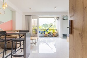 A modern living room with a dining area, a hammock, and a view of greenery outside. - Utopia 4.East - Cosmopolitan Loft•Self Check-In•AC (Medellín)