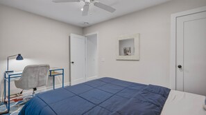 A bedroom with a bed, a desk, a chair, a ceiling fan, and a door. - Private East Hampton Oasis with Heated Pool & hot tub, Modern Interiors,... (East Hampton)