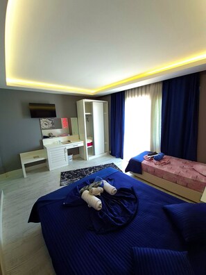 A hotel room with a bed, a desk, a wardrobe, and a television.