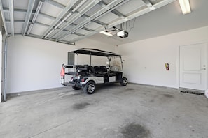 A garage with a golf cart parked inside. - Free 6-Seater Golf Cart, Private Pool & Spa, Putting Green (Panama City Beach)