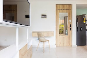 Eine moderne Küche mit integriertem Kühlschrank, einer Holztür und einem flachbildfernseher an der Wand.