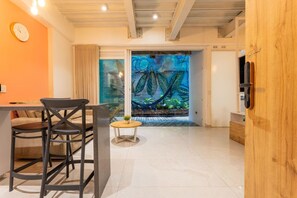 A modern interior with a dining area, a hammock, and a large window with a tropical mural. - Utopia S.East – Quiet Loft•Wi-Fi•Self Check-In (Medellín)