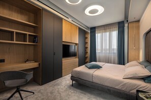 Un dormitorio moderno con cama, escritorio y estanterías empotradas.