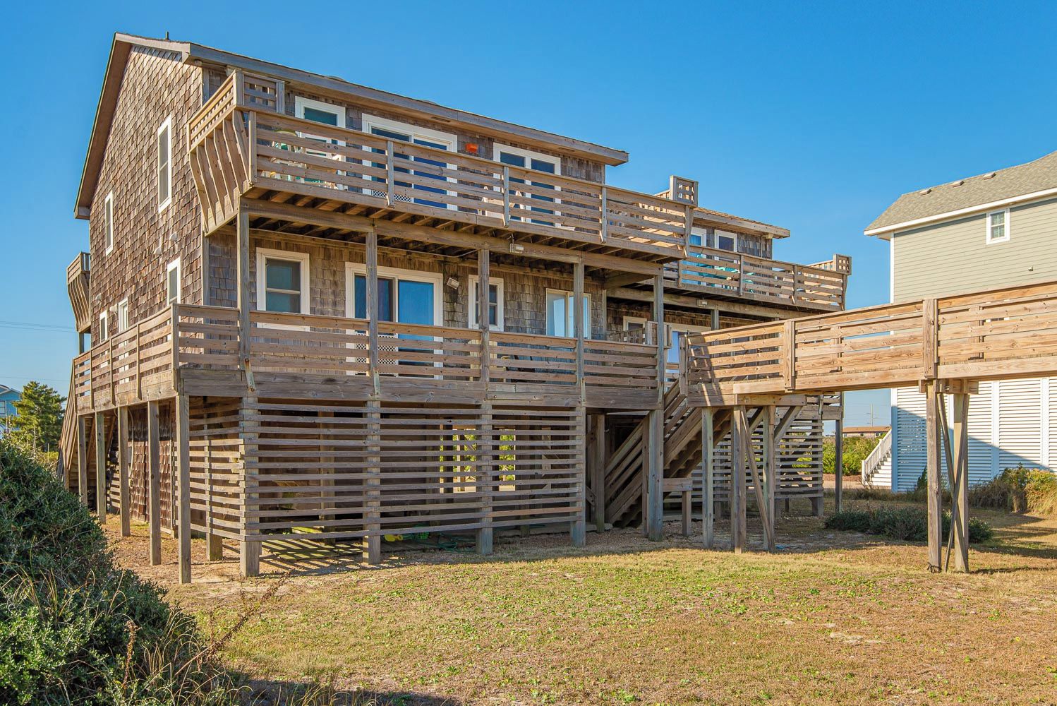 A two-story wooden structure with a balcony and a staircase leading to the upper level.