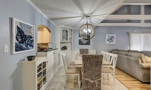 A dining area with a table and chairs, a chandelier, and a sofa in the background. - Dog Friendly Villa w/ Community Amenities (Hilton Head Island)