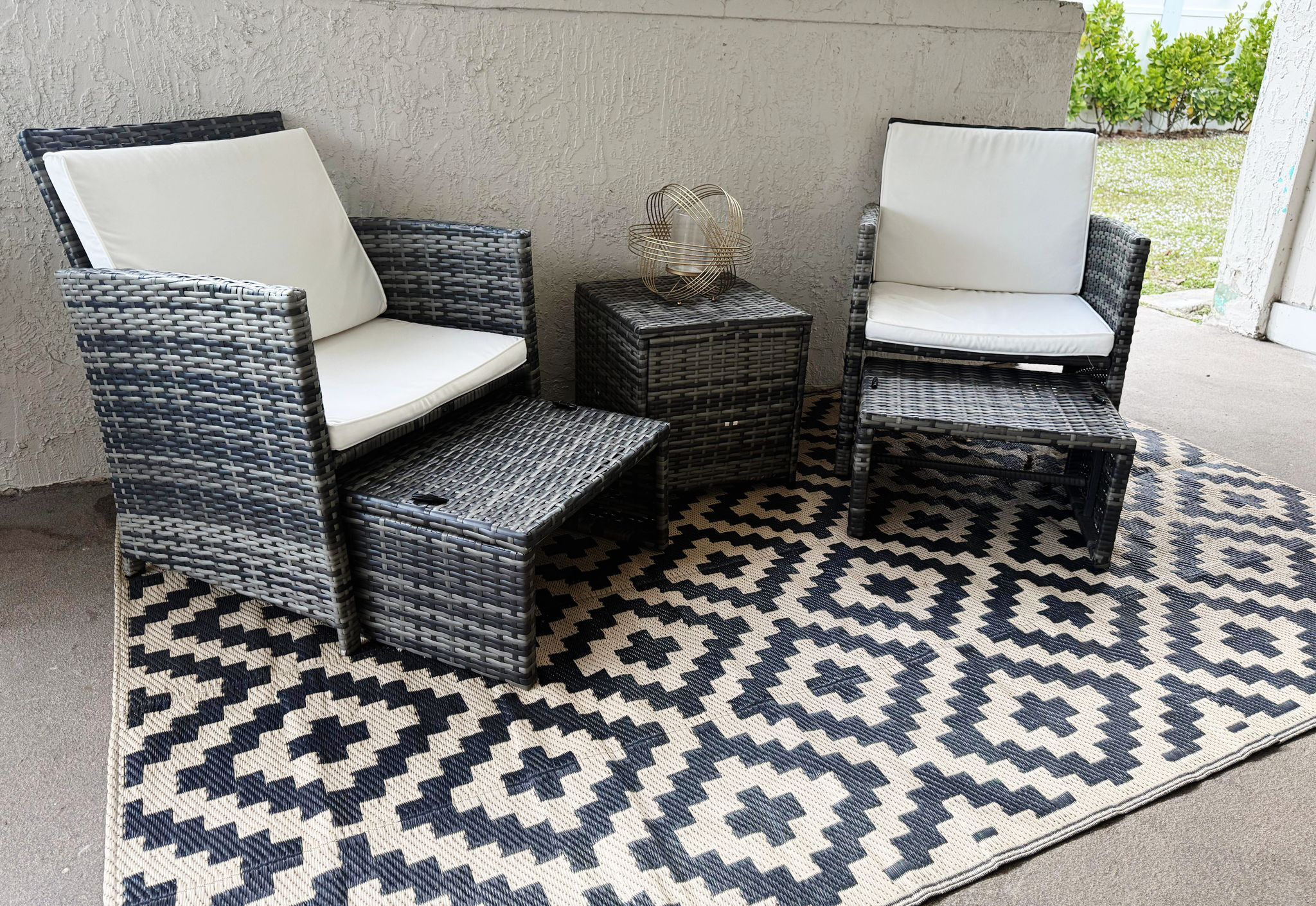 Un coin salon avec deux fauteuils en osier et une petite table d’appoint.