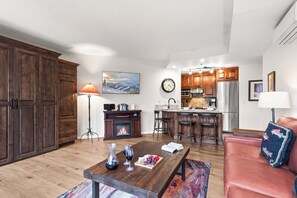 Un soggiorno moderno con camino, zona pranzo e cucina con mobili in legno.