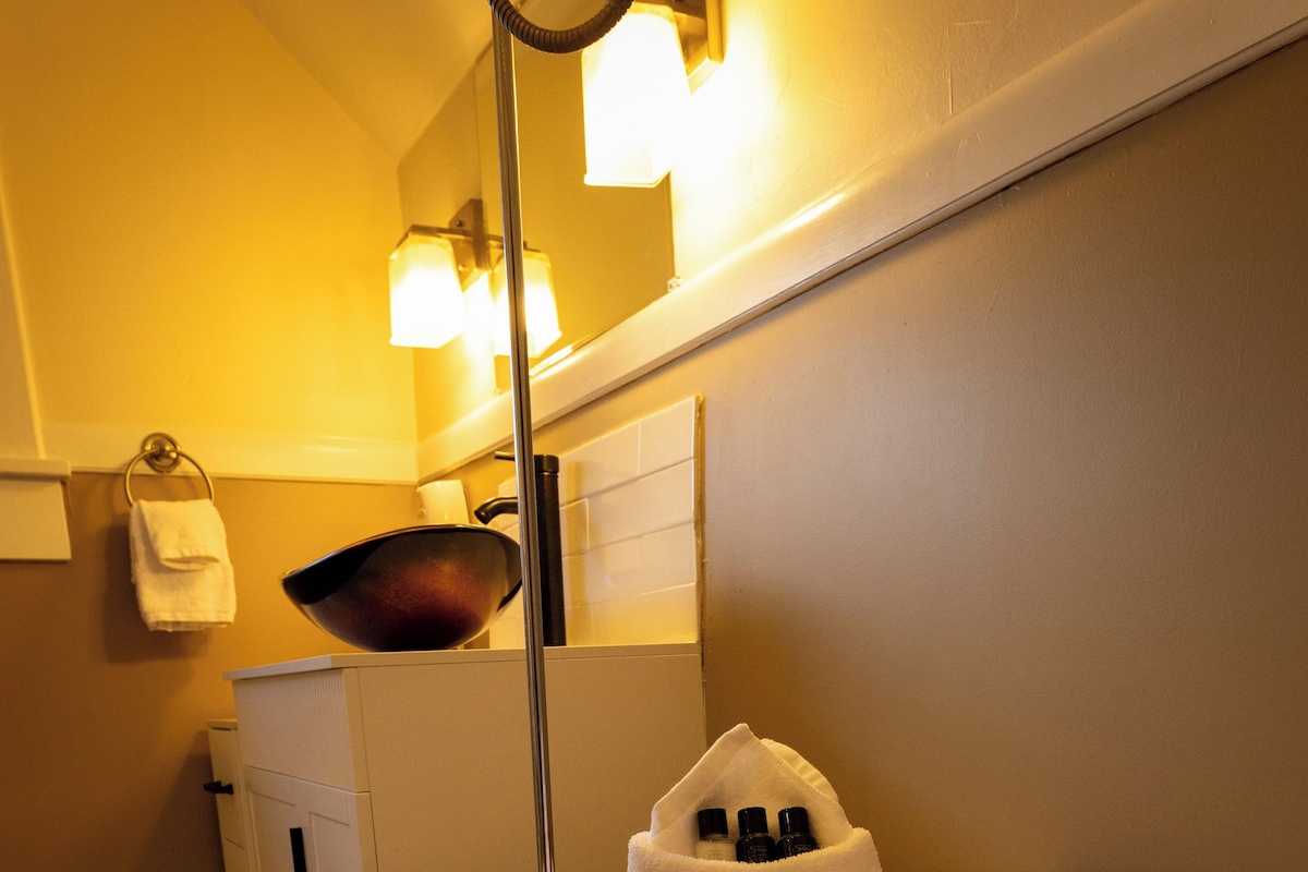 Un baño con una bañera, repisa de madera, toalla y espejo.