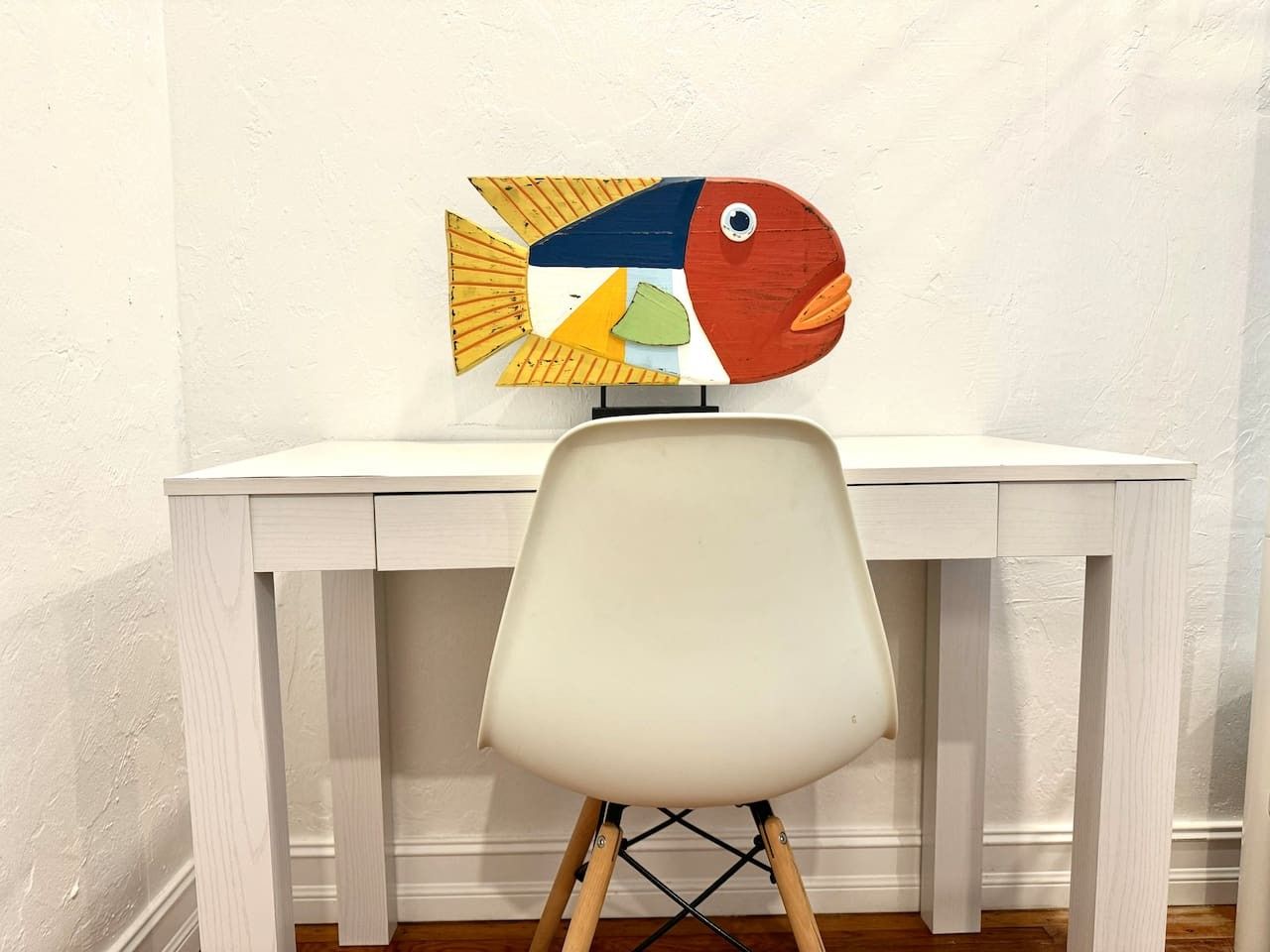 A white desk with a chair in front of it.